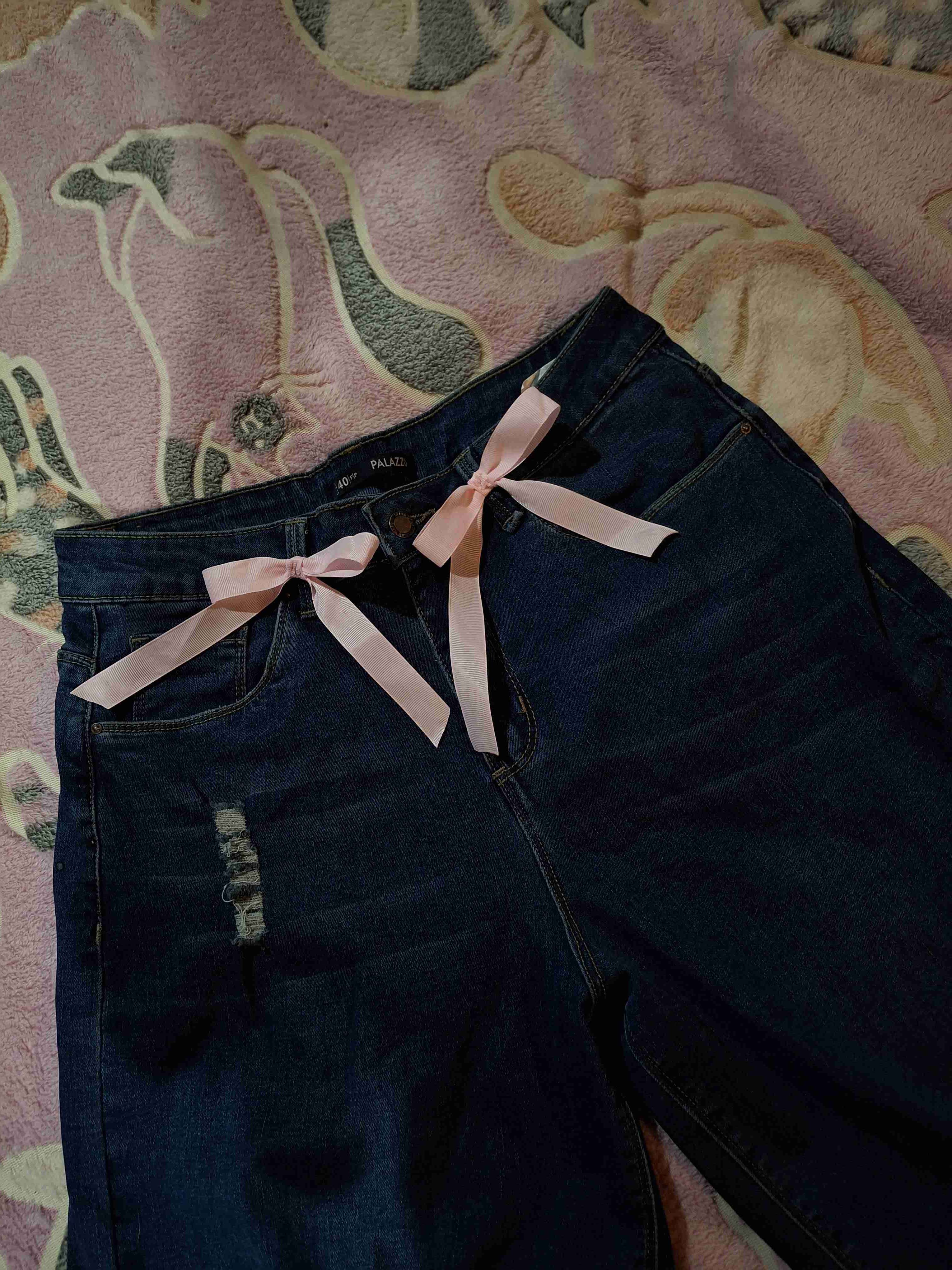 Jeans oscuros con lazo rosado