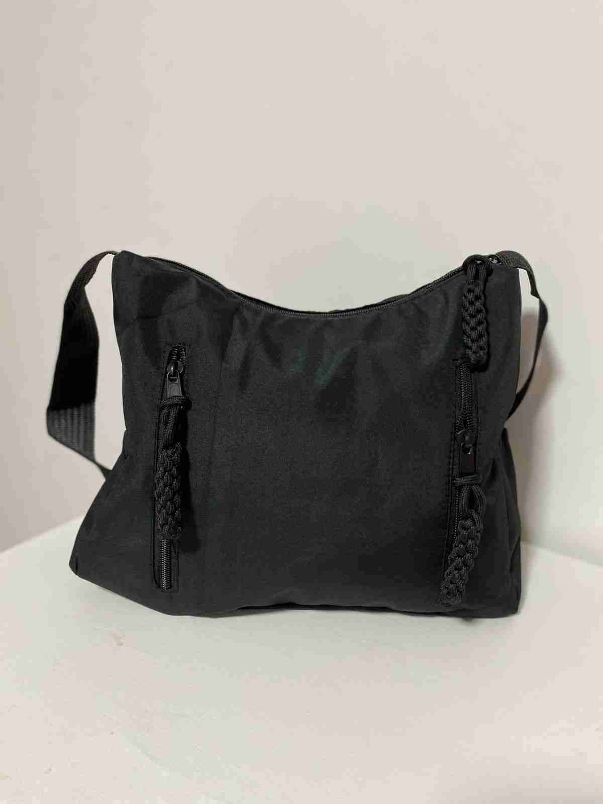 Cartera negra con correas trenzadas