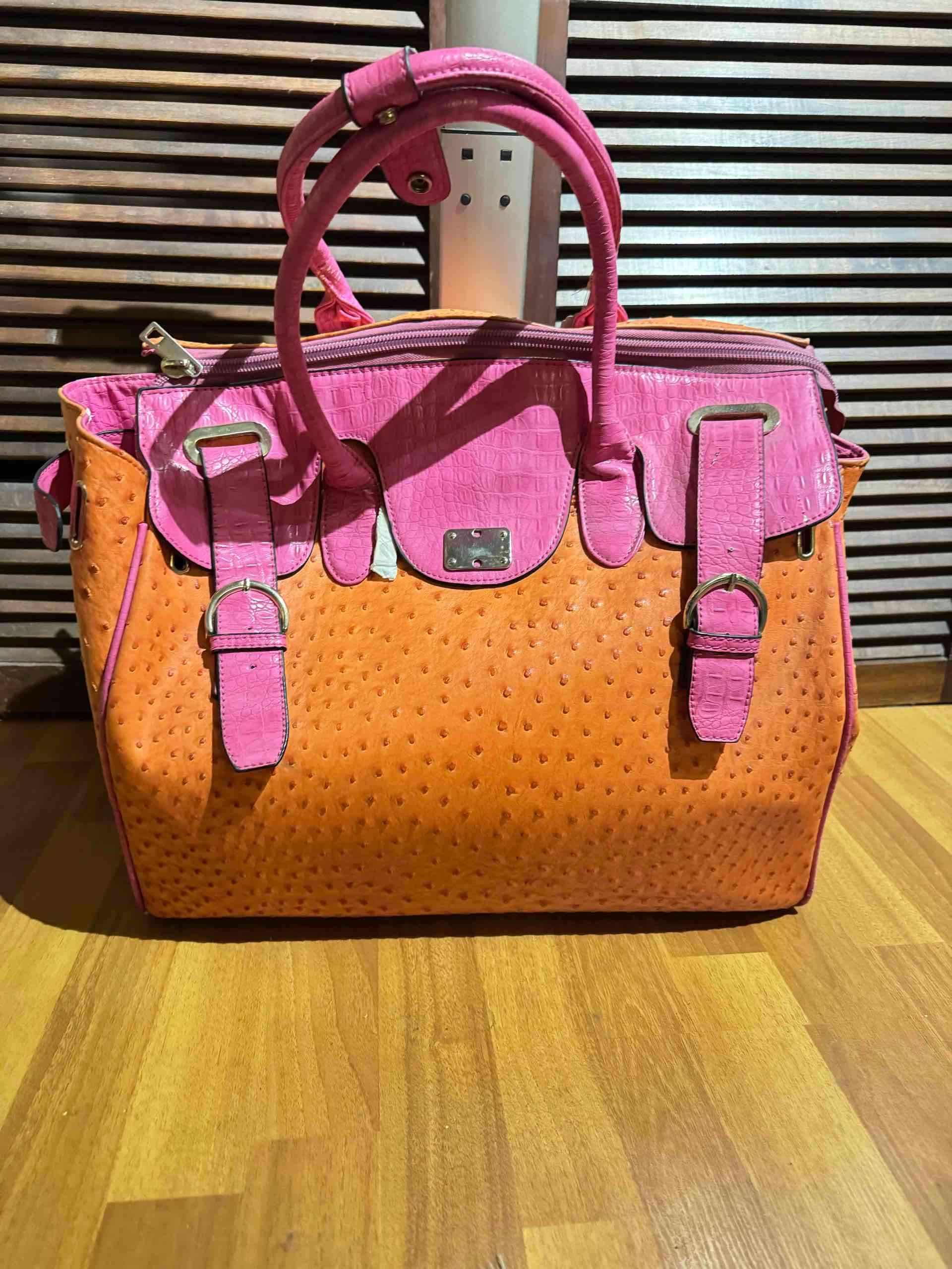Bolso de mano color rosa y naranja con carro