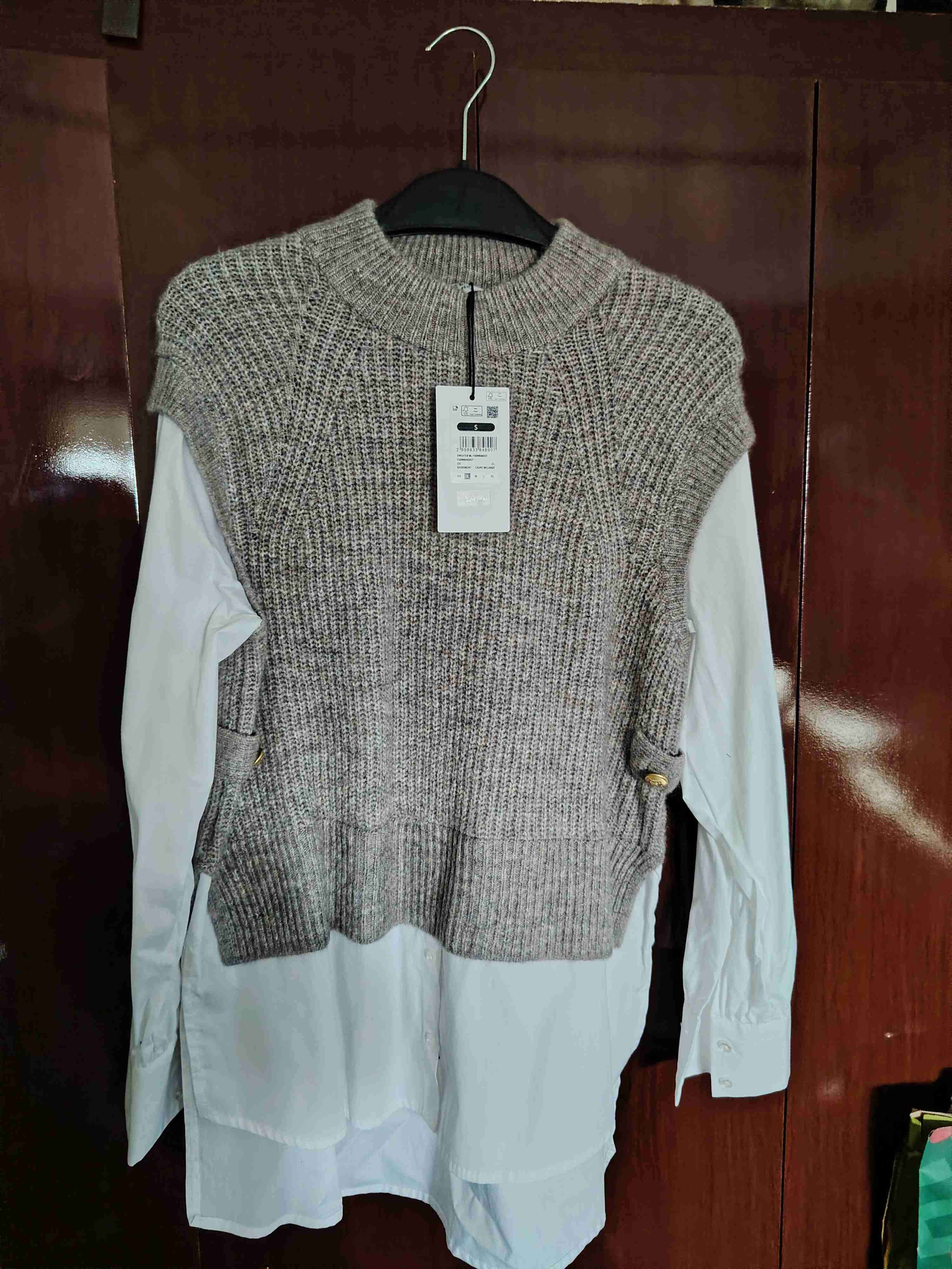 Suéter gris sobre camisa blanca