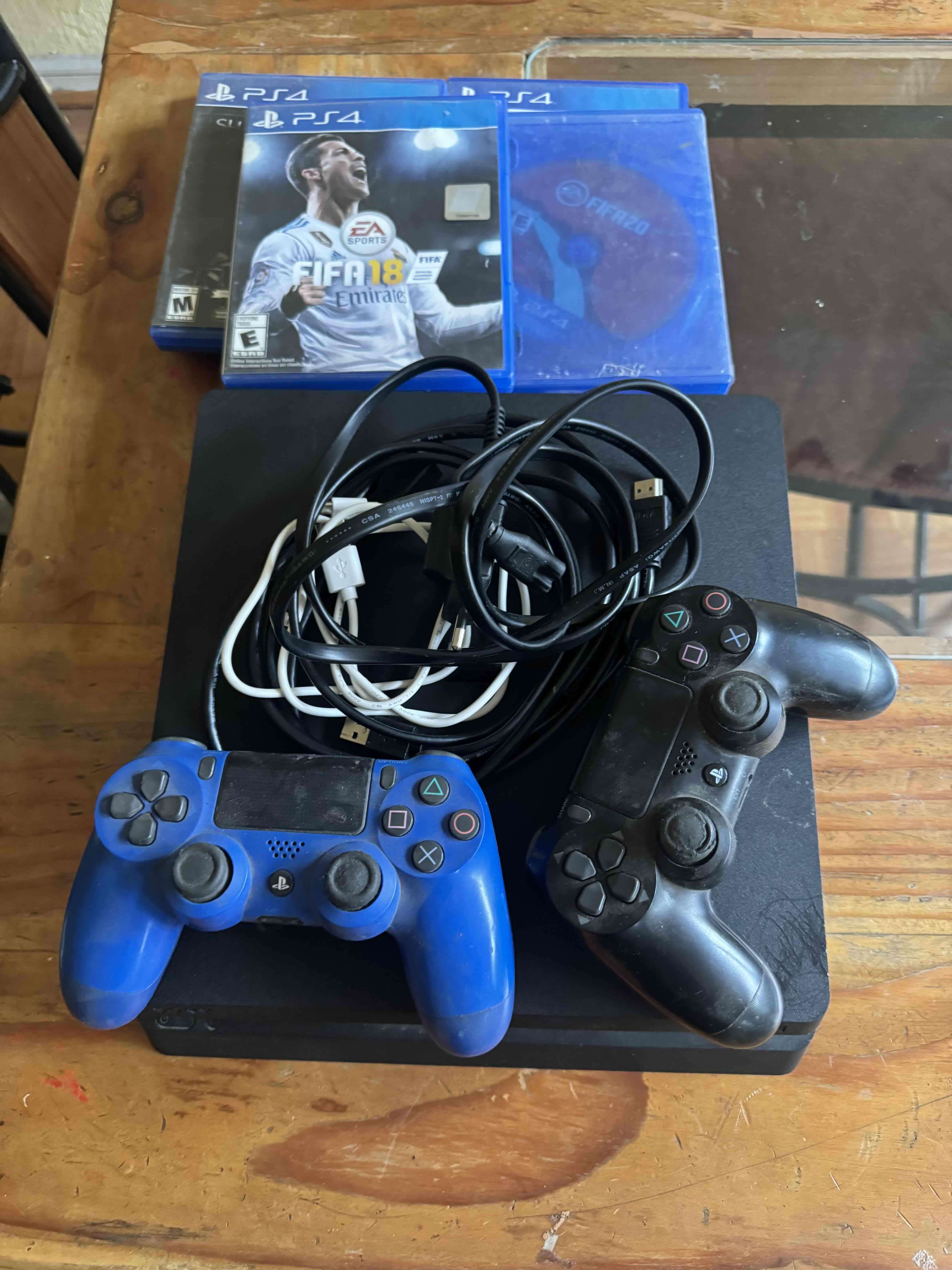 Consola PS4 con dos controles y juegos