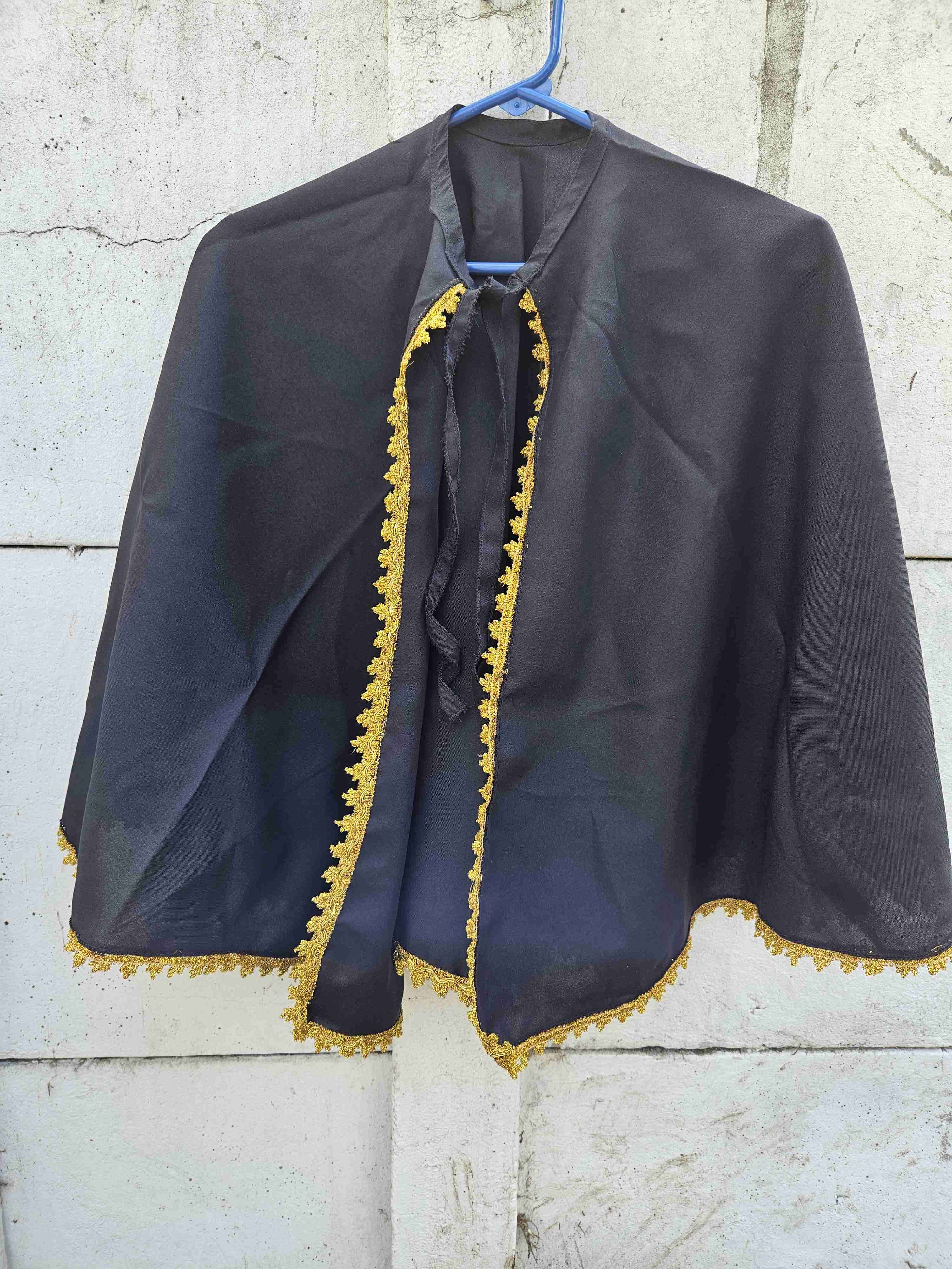 Capa corta, negra con ribete dorado