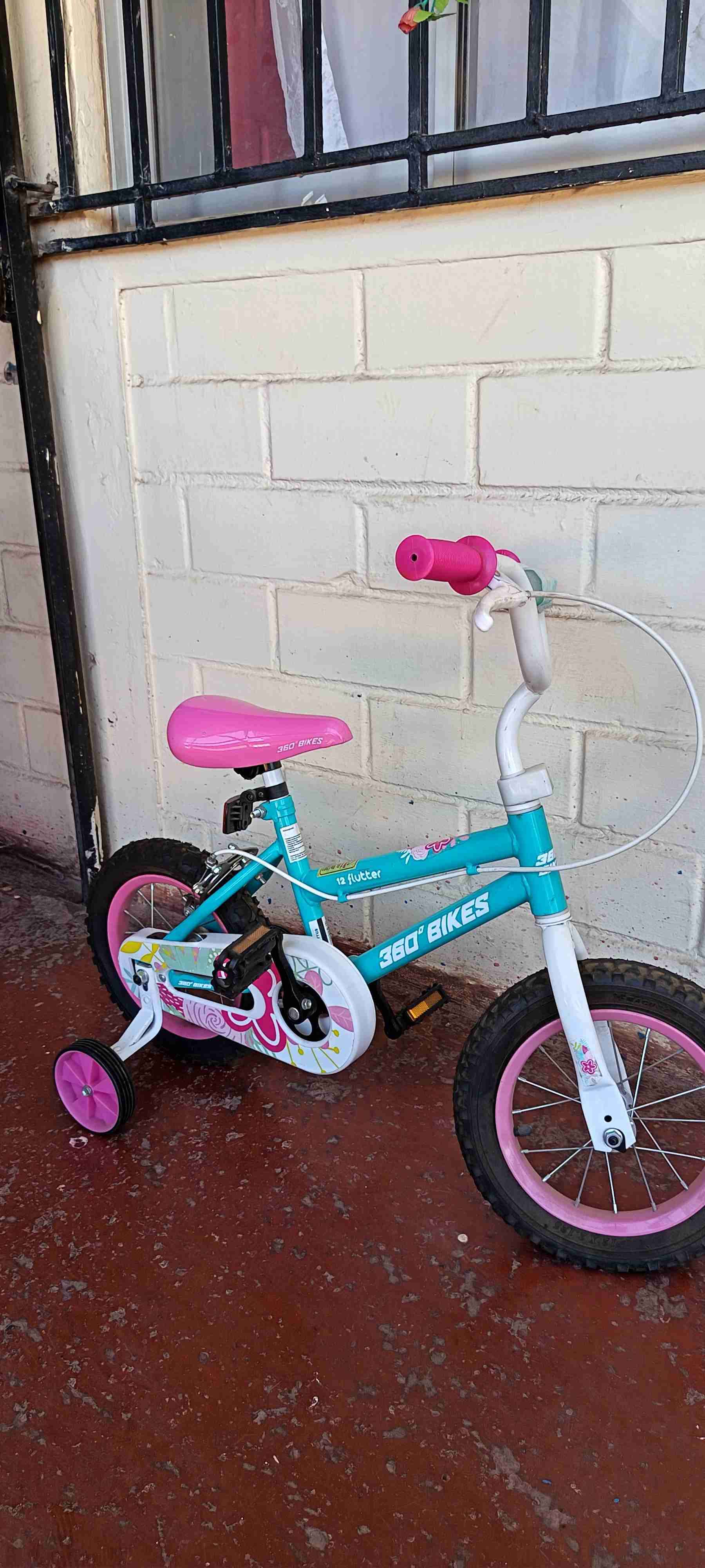 Bicicleta infantil rosa con rodines